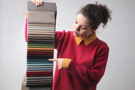 Girl choosing a color for fabricの写真素材