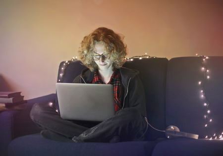 Guy using a laptop on a sofaの写真素材