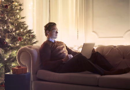 Man using a laptop on a sofaの写真素材
