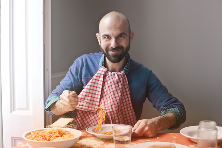 Happy man eating spaghettiの写真素材