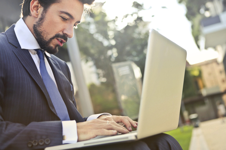 Businessman using a laptop outdoorの写真素材