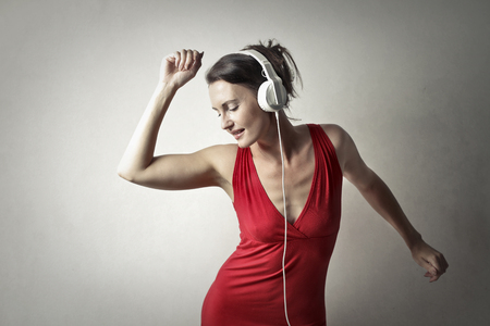 Girl listening to music with headphones and dancingの写真素材