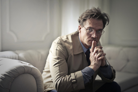 Serious man sitting on a sofaの写真素材