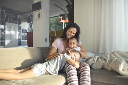 A woman with two children at homeの写真素材