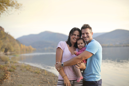 Happy family near a lakeの写真素材
