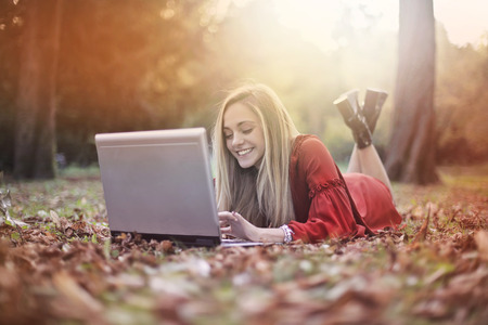 Girl using a laptop in a natural contextの写真素材