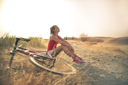 Girl with a bike relaxing in the countrysideの写真素材