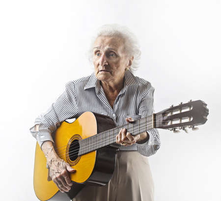 Aged woman playing acoustic guitarの写真素材