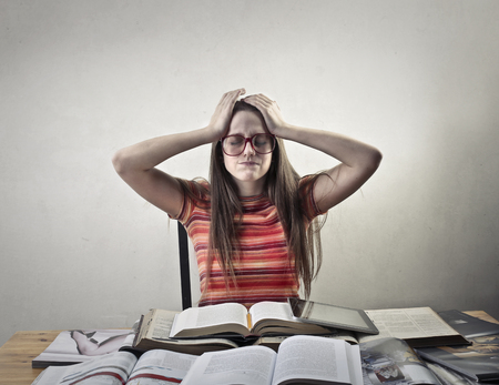 Desperate student girl with booksの写真素材