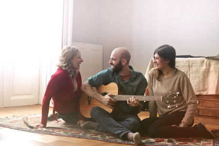 Group of adult friends playing guitar and having funの写真素材