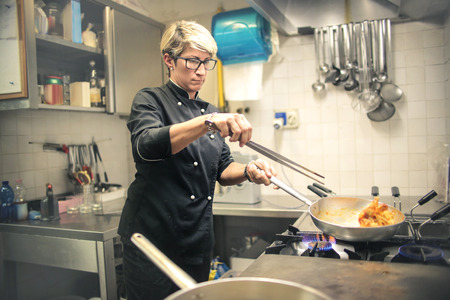 Chef cooking pasta in a restaurant kitchenの写真素材