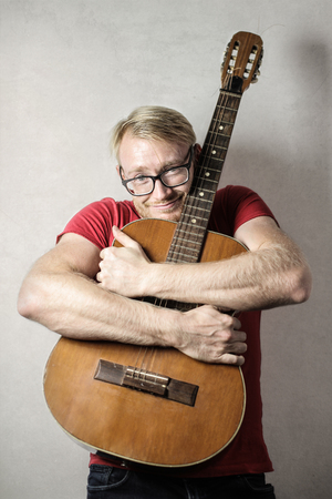 Man hugging his acoustic guitarの写真素材
