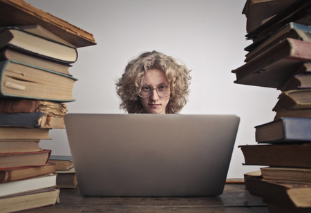 Student boy with a laptop and a lot of booksの写真素材