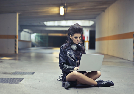 Grunge girl with a smartphone in a underground parkingの写真素材
