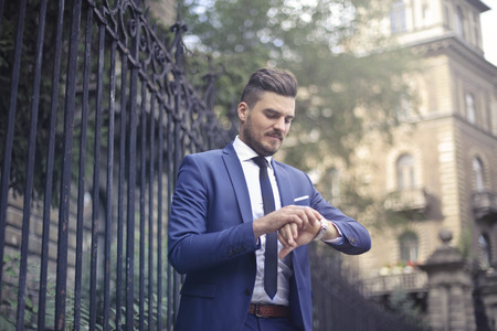 Businessman checking the watch outdoorの写真素材