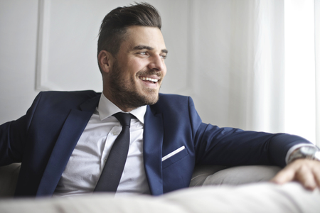 Positive businessman sitting on a sofaの写真素材