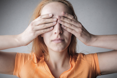 Woman covering her eyes with handsの写真素材