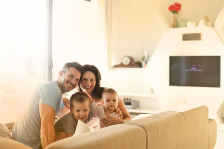 Family of four relaxing on a sofaの写真素材