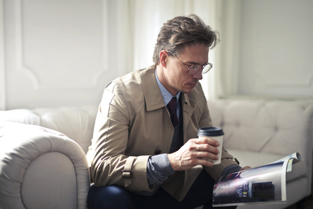 Businessman with a coffee and a magazineの写真素材