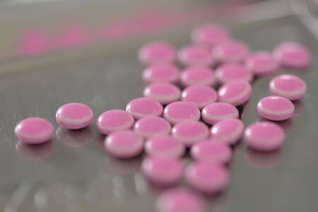 Pink medicine on tray .
