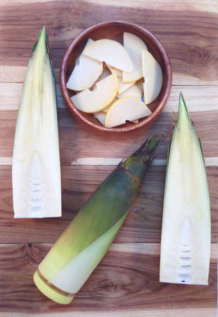 Bamboo shoots and Bamboo shoots slices in wooden bowl on wooden backgroundの写真素材