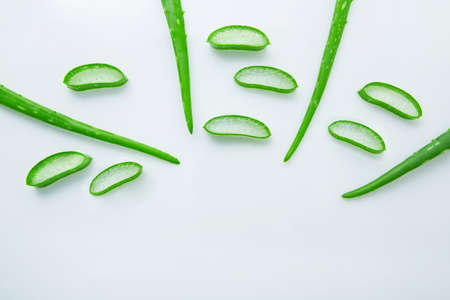 Aloe vera fresh leaves with slices aloe vera gel on wooden spoon. isolated over whiteの写真素材