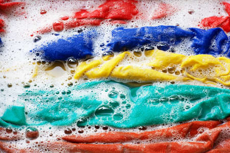 Color clothes soak in water with washing powder, before washing.