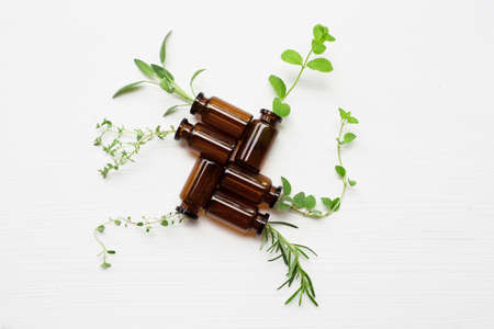 Top view, Bottle of essential oil with herbs  sage, rosemary, oregano, mint, thyme and lemon thyme  on white background.の写真素材