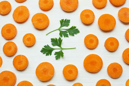 Chopped carrot slices with parsley leaves  isolated on white background.の写真素材
