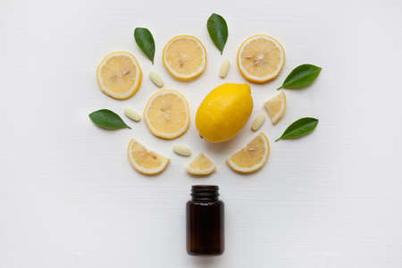 Brown Bottle with lemon, leaves and vitamin C. on white background.