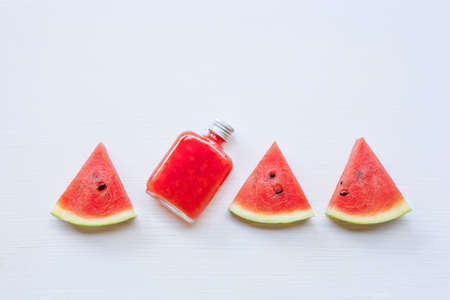 Bottle of fresh watermelon juice with  watermelon pieces  on white.の写真素材