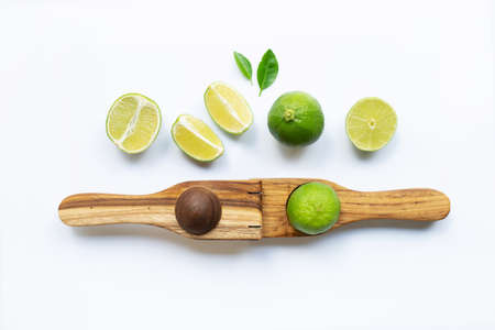 Limes with wooden lime Squeezer on white background.の写真素材