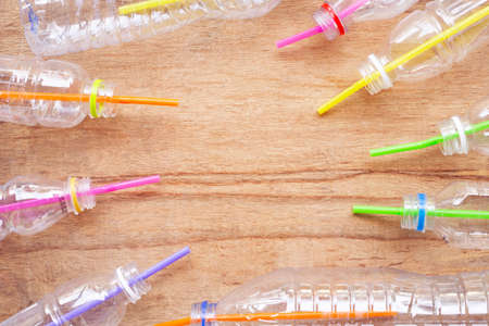 Plastic waste, Plastic bottles with straws on wooden background.の写真素材