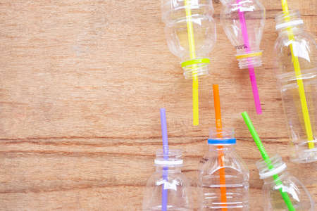 Plastic waste, Plastic bottles with straws on wooden background.の写真素材