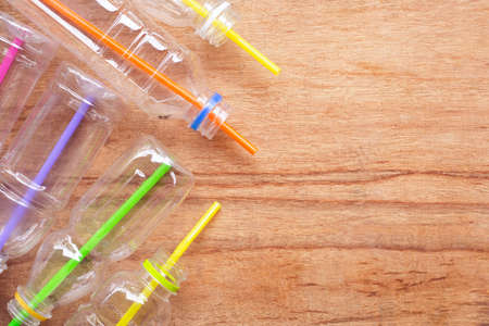 Plastic waste, Plastic bottles with straws on wooden background.の写真素材