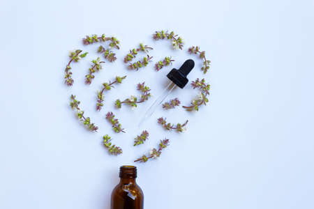 Flower of sweet basil with drop bottle of essential oil herb on white backgroundの写真素材