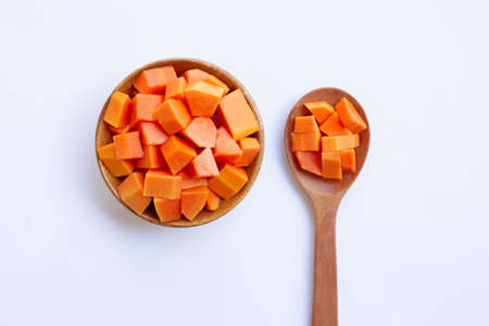 Ripe cut papaya on wooden bowl and spoon on white backgroundの写真素材