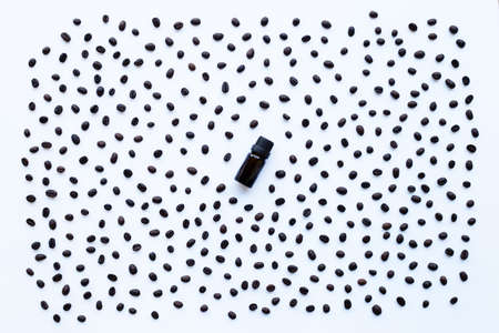 Glass bottle with essential oil of coffee and Coffee grains on white backgroundの写真素材
