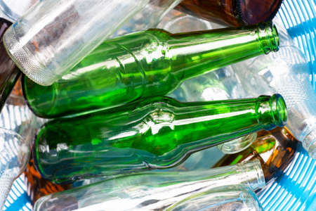 Glass bottles in blue waste basket.の写真素材