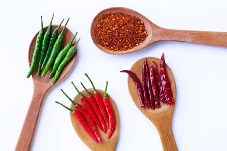 Hot chili pepper on  wooden spoon, white background.