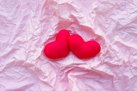 Valentine's hearts on pink crumpled paper background. Top viewの写真素材