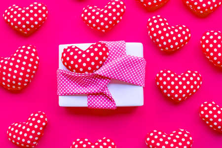 Gift box with Valentine's hearts on red background. Top view