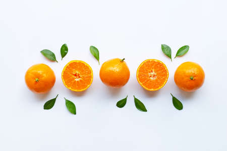 Orange fruits and green leaves on a white background. Top viewの写真素材