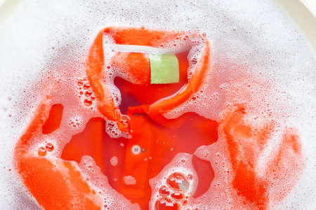 Soak a cloth before washing, Orange polo shirtの写真素材