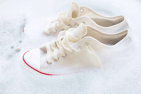 Soak shoes before washing. Cleaning Dirty sneakers.の写真素材