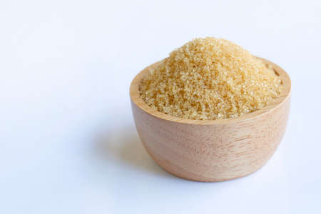 Brown sugar in wooden bowl on white background.の写真素材