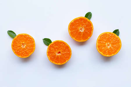 Orange fruits and green leaves on a white background. Top view