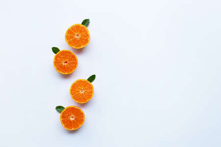 Orange fruits and green leaves on a white background. Top viewの写真素材