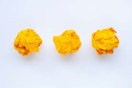Yellow crumpled paper ball isolated on white background.