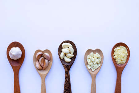 Garlic on wooden spoon on white backgroundの写真素材